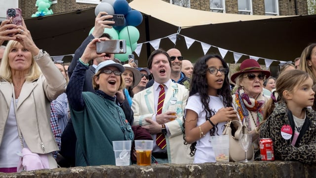 A crowd watches the race from Putney