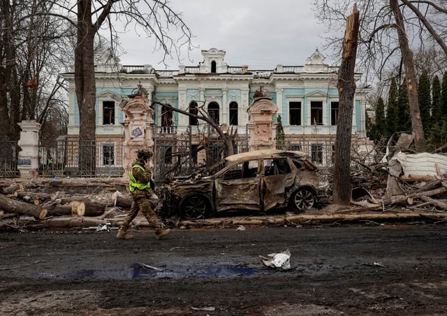 Un militaire ukrainien marche sur le site d’une frappe de missile russe, à Soumy, Ukraine, le 13 avril 2025.
