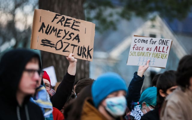 Protesters hold signs reading "Free Rumeysa Ozturk" and "come for one face us all! solidarity forever" during a demonstration in Somerville, Massachusetts.