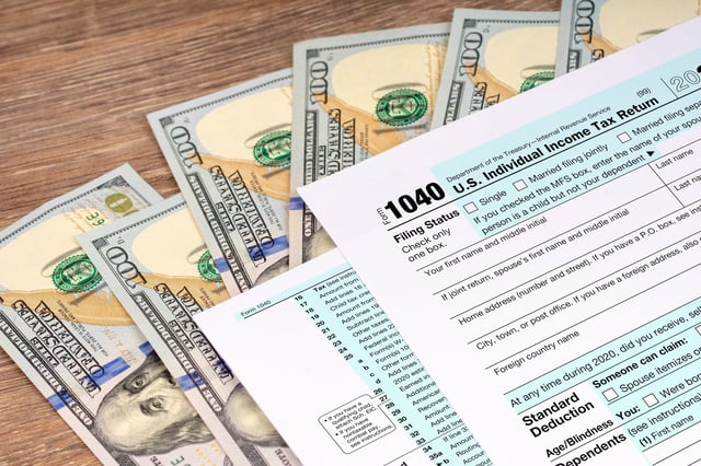 Stock image/file photo: An IRS Form 1040 with U.S. Dollars.