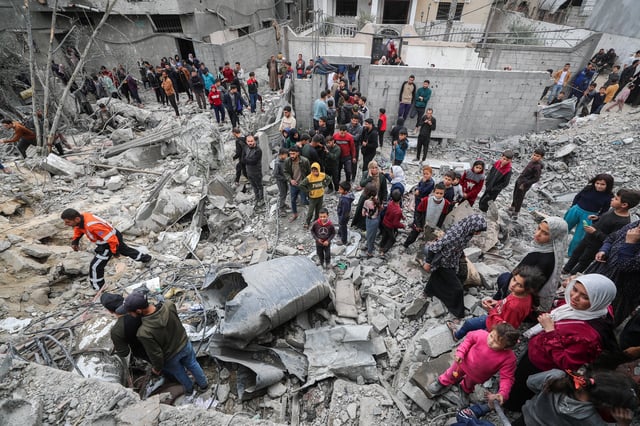 Palestinians gather at the site of an Israeli strike on a house as rescuers attempt to remove casualties from under the rubble, in Jabalia in the northern Gaza Strip April 13, 2025. REUTERS/Mahmoud Issa/File Photo