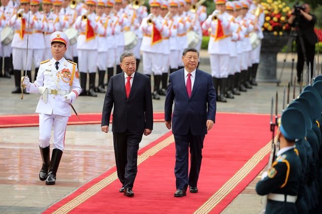 Vietnam&#39;s General Secretary of the Communist Party To Lam (center) and Chinese President Xi Jinping (right) review the guard of honor during a ceremonial welcome at the Presidential Palace in Hanoi on April 14, 2025.