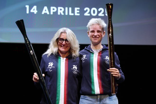 2026 Milano Cortina Winter Olympics - News conference to present Olympic and Paralympic torches - Milan, Italy - April 14, 2025 Former Italian cross-country skier Stefania Belmondo and Paralympian Beatrice Vio hold the 2026 Milano Cortina Winter Olympics and Paralympic torches during a ceremony REUTERS/Claudia Greco
