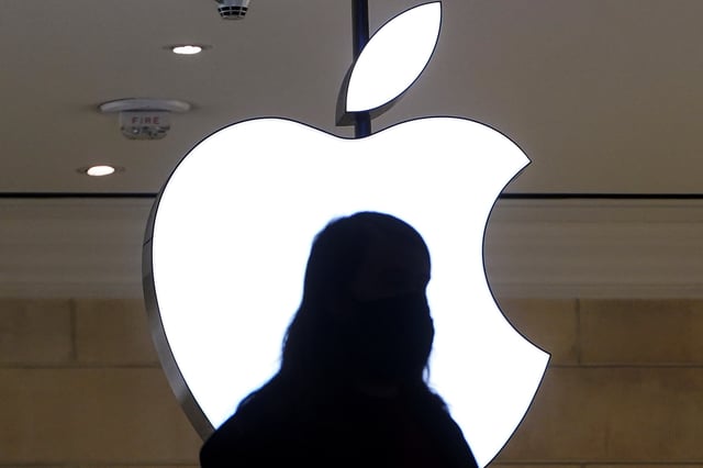 A person is silhouetted against a logo sign of the Apple Store in the Grand Central Terminal in the Manhattan borough of New York City, New York, U.S., January 4, 2022.  REUTERS/Carlo Allegri/File Photo