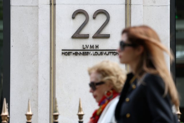 Women walk past the logo of LVMH Moet Hennessy Louis Vuitton in front of the LVMH luxury group headquarters in Paris, France, April 14, 2025. REUTERS/Sarah Meyssonnier