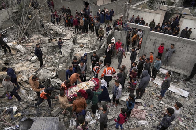Volunteers and emergency workers remove a body from the rubble of the Manoun family's house after it was targeted by an Israeli army strike in Jabalia al-Balad, Gaza City, Sunday, April 13, 2025. (AP Photo/Jehad Alshrafi)