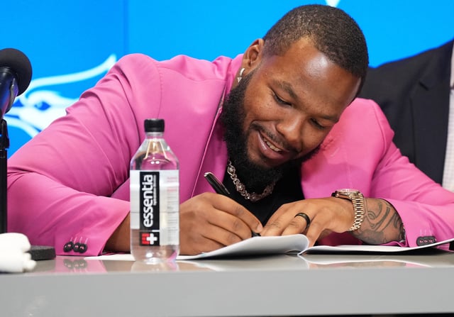 Apr 14, 2025; Toronto, Ontario, Canada; Toronto Blue Jays first baseman Vladimir Guerrero Jr. signs the contract during the press conference at Rogers Centre. Mandatory Credit: Nick Turchiaro-Imagn Images