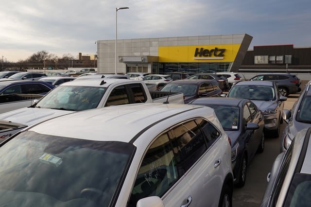 Cars are parked near Hertz car rental signage at John F. Kennedy International Airport in Queens, New York City, U.S., March 30, 2022. REUTERS/Andrew Kelly