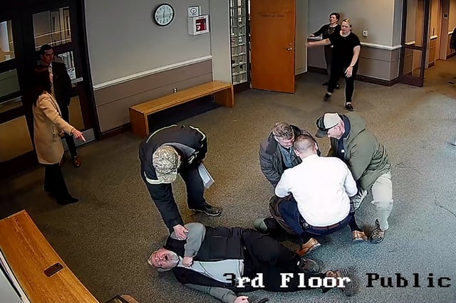 A bystander who was knocked down during an arrest by federal agents of Arnuel Marquez Colmenarez, a 33 year old Venezuelan man, is checked for injuries, in a still image from surveillance camera video taken in Nashua, New Hampshire, U.S. February 20, 2025.   New Hampshire Judicial Branch/Handout via REUTERS