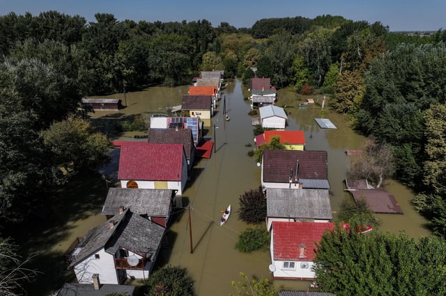 A drone view shows a man rowing a boat among houses flooded by the Danube River in the village of Ersekcsanad, Hungary, September 22, 2024. REUTERS/Marko Djurica/File Photo
