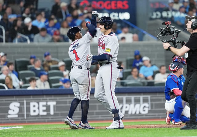 Apr 14, 2025; Toronto, Ontario, CAN; Atlanta Braves third baseman Austin Riley (27) hits a three run home run and celebrates with  second baseman Ozzie Albies (1) against the Toronto Blue Jays during the fifth inning at Rogers Centre. Mandatory Credit: Nick Turchiaro-Imagn Images