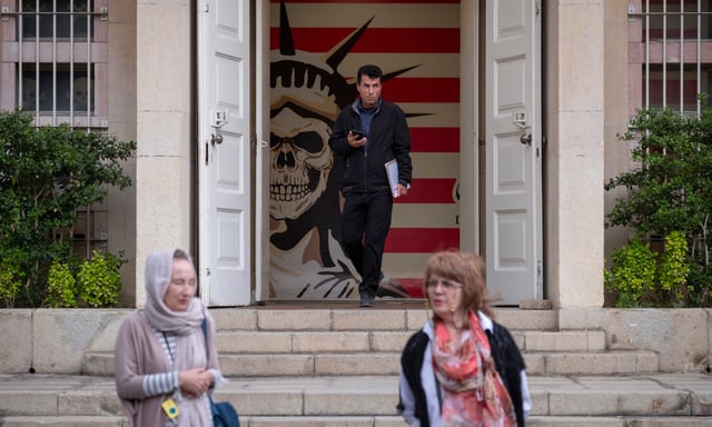 Trois personnes visitent l'ex-ambassade américaine à Téhéran, le 12 avril, le jour où ont lieu des négociations irano-américaines indirectes à Oman  
 (Photo by Morteza Nikoubazl/NurPhoto) (Photo by Morteza Nikoubazl / NurPhoto / NurPhoto via AFP)
