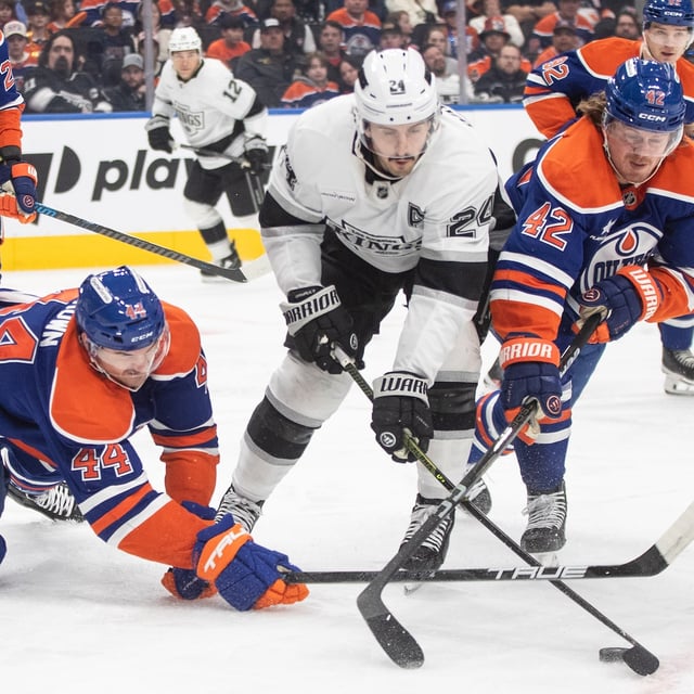 Los Angeles Kings' Phillip Danault (24) battles for the puck with Edmonton Oilers' Joshua Brown (44) and Kasperi Kapanen (42) during first period NHL action in Edmonton, Monday, April 14, 2025. THE CANADIAN PRESS/Jason Franson