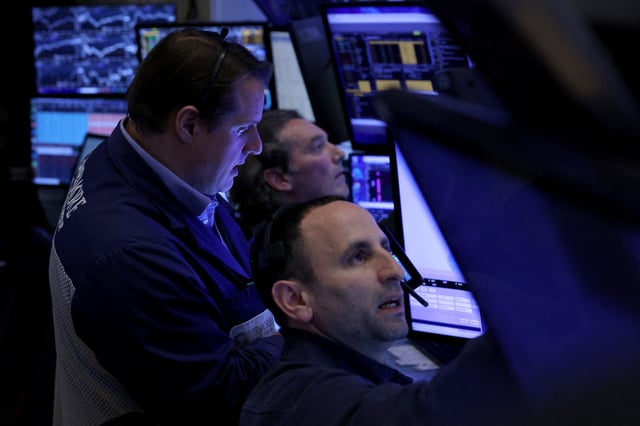 Traders work on the floor at the New York Stock Exchange (NYSE) in New York City, U.S., April 14, 2025.  REUTERS/Brendan McDermid/File Photo