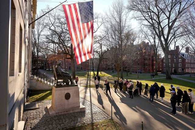 FILE - People take photos near a John Harvard statue, left, on the Harvard University campus, Jan. 2, 2024, in Cambridge, Mass. Two task forces charged with proposing ways to combat anti-Muslim, anti-Arab, and anti-Palestinian bias and antisemitism at Harvard University have delivered their preliminary recommendations to Harvard interim president Alan Garber. (AP Photo/Steven Senne, File)
