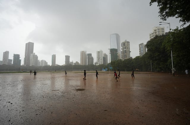 Children play in the rain in Mumbai, India, June 20, 2024. REUTERS/ Hemanshi Kamani/File Photo