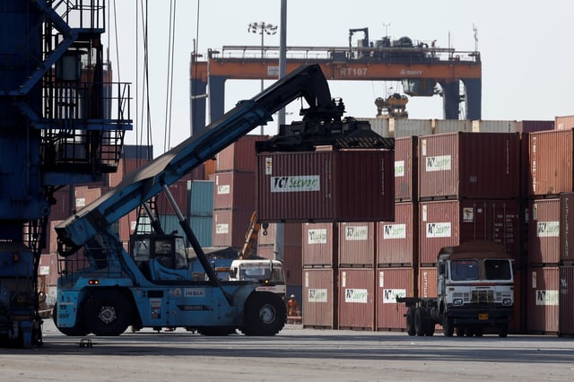 A mobile crane carries a container at Deendayal Port in Kandla, in the western state of Gujarat, India, April 5, 2025.  REUTERS/Amit Dave/ File Photo