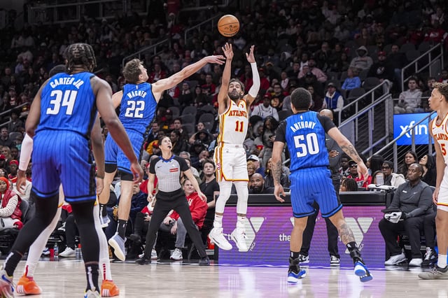 Atlanta Hawks guard Trae Young (11) shoots from the outside over Orlando Magic forward Franz Wagner (22).