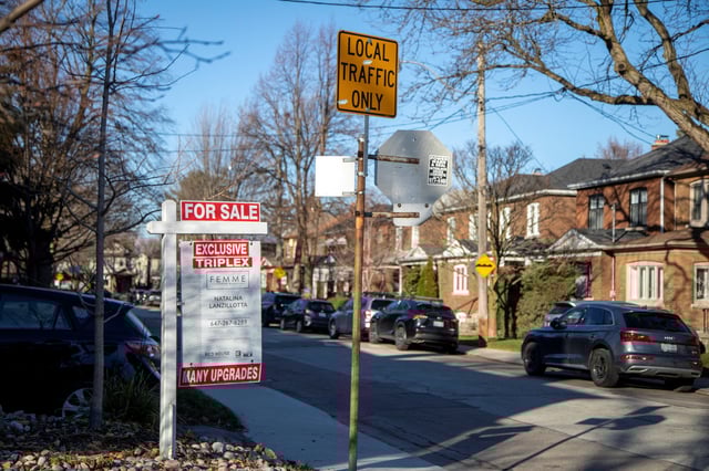 A for sale sign is displayed outside a home in Toronto, Ontario in Toronto, Ontario, Canada December 13, 2021.  REUTERS/Carlos Osorio/File Photo