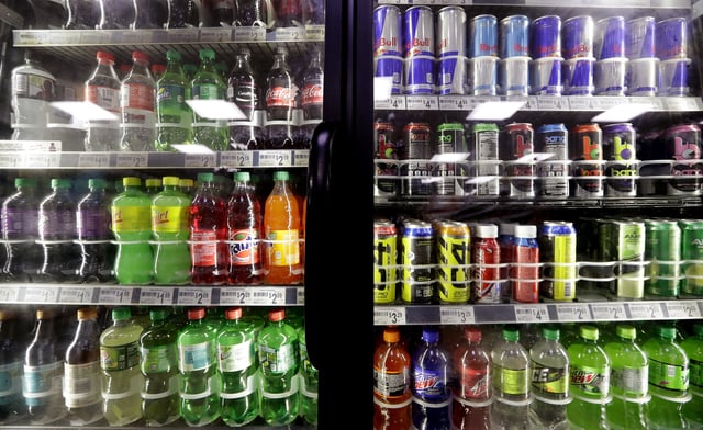 FILE - Soft drinks fill a drink cooler in a convenience store in Kent, Wash., Oct. 1, 2018. (AP Photo/Elaine Thompson, File)