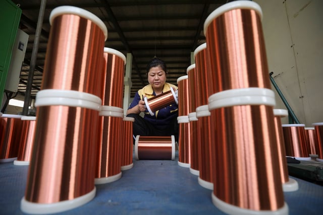 A worker processes copper wire at a workshop in Huai 'an City, East China's Jiangsu Province,  on June 28, 2023.