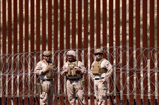 Members of the U.S. military stand in front of the border wall along the U.S. and Mexico border near San Ysidro last month, part of Trump administration efforts to stop the flow of migrants from entering the U.S.