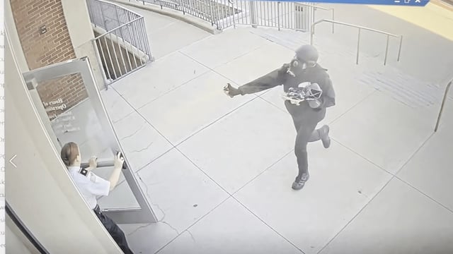 Surveillance footage shows a man in a helmet and gas mask pepper-spraying a court officer at Woburn District Court on Monday, April 14, 2025.