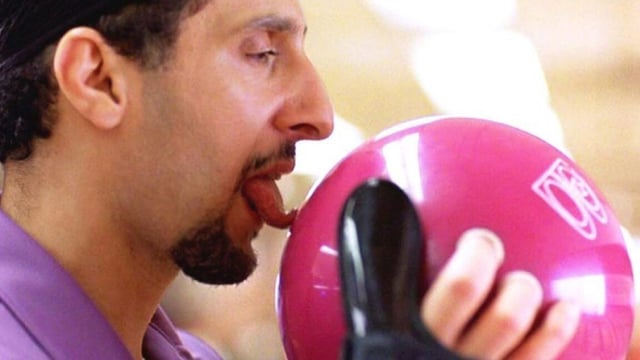 Jesus Quintana (John Turturro) licks a red bowling ball before throwing in a scene from The Big Lebowski