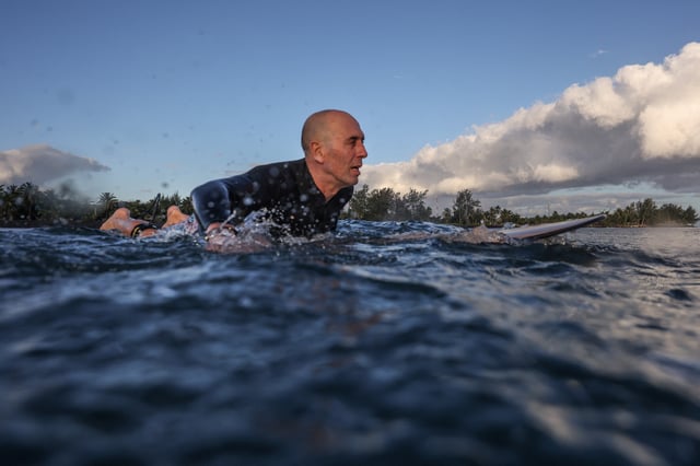 Fernando Aguerre, president of the International Surfing Association waits for a wave as he surfs at a local beach in Papara, Tahiti, July 24, 2024. REUTERS/Carlos Barria