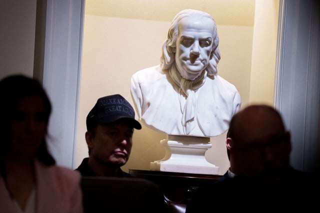 Tesla and SpaceX CEO Elon Musk, head of the Department of Government Efficiency (DOGE), sits in front of a bust of Ben Franklin as he attends a Cabinet meeting at the White House on February 26, 2025, in Washington, D.C.
