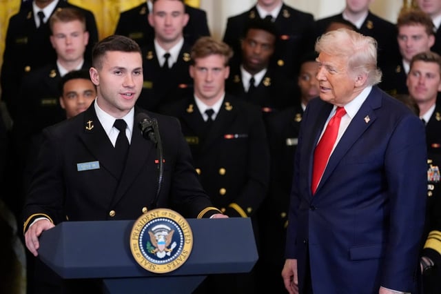 President Donald Trump listens as Colin Ramos speaks during the Commander-in-Chief trophy presentation in the East Room of the White House on Tuesday in Washington. (AP Photo/Alex Brandon)