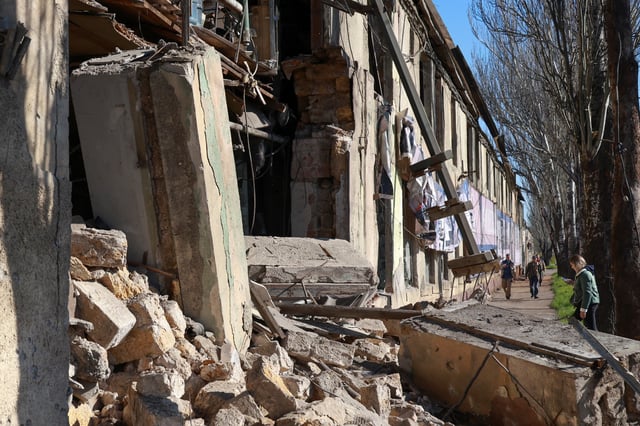 Residents are seen next to a building damaged during a Russian drone strike, amid Russia's attack on Ukraine, in Odesa, Ukraine April 14, 2025. REUTERS/Nina Liashonok