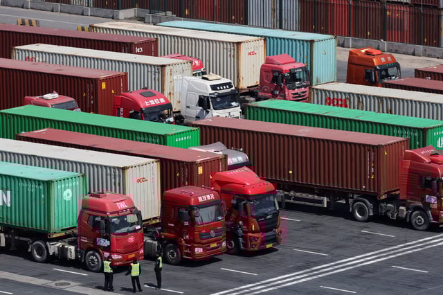 Trucks loaded with shipping containers are parked outside a gate while waiting to enter Yangshan Port outside of Shanghai, China, April 15, 2025.  REUTERS/Go Nakamura