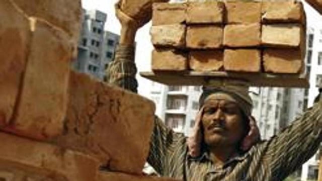 A labourer stacks bricks on his head at the construction site. (Reuters File Photo)