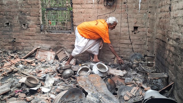 A man goes through the charred remains in a house at the violence-affected Samsergunj area, in Murshidabad on Tuesday. Following the violent protests against the Waqf (Amendment) Act 2025, the displaced families took refuge in adjoining Malda district. 