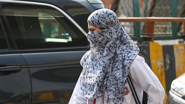 As temperatures rise in Delhi-NCR, commuters cover their heads to escape the heat in Sector 38A, in Noida,
