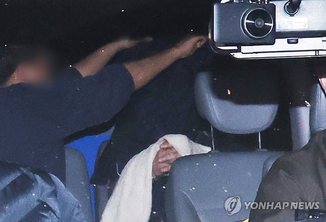 A man in his 50s who allegedly killed five of his family members is escorted to a police station in Yongin, some 40 kilometers south of Seoul, on April 15, 2025. (Yonhap)