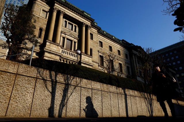 A passerby walks past in front of the Bank of Japan headquarters in Tokyo, Japan January 23, 2025.  REUTERS/Issei Kato/File Photo