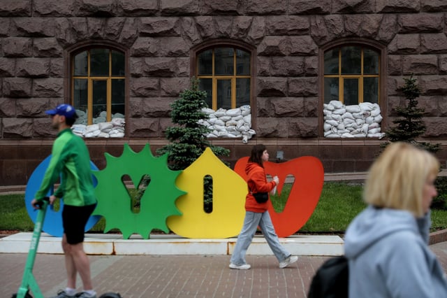 Sandbags are placed on a public building's windows while local residents walk past a sign reading 'Kyiv', as Russia's attack on Ukraine continues, in Kyiv, Ukraine May 22, 2022. REUTERS/Ivan Alvarado/File Photo