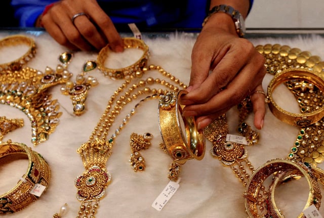 A woman looks at a gold bangle inside a jewellery showroom at a market in Mumbai January 15, 2015. REUTERS/Shailesh Andrade/File Photo