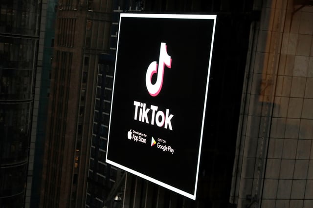 The TikTok logo is seen on a screen over Times Square in New York City, U.S., March 6, 2020. REUTERS/Andrew Kelly/ File Photo