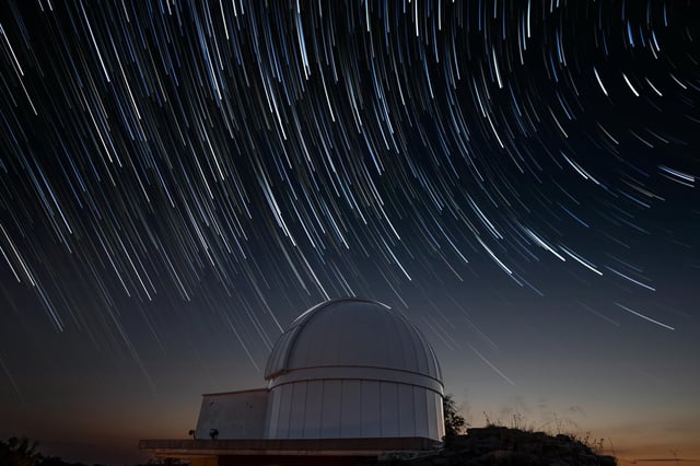 Pictured: Stock image of an astronomical observatory under a sky of star trails at night.