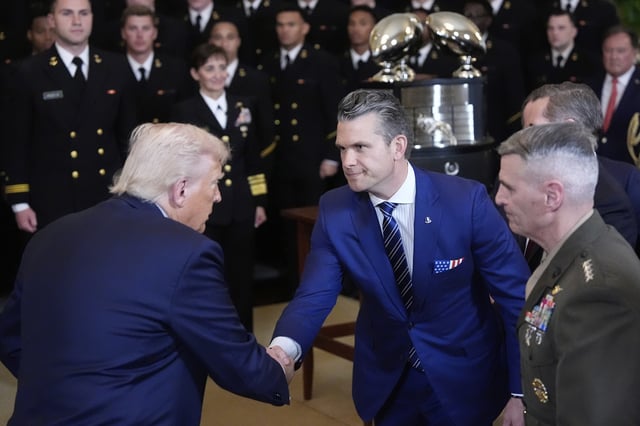 President Donald Trump shakes hands with Defense Secretary Pete Hegseth at the Commander-in-Chief trophy presentation to the Navy Midshipman football team in the East Room of the White House, Tuesday, April 15, 2025, in Washington. (AP Photo/Alex Brandon)