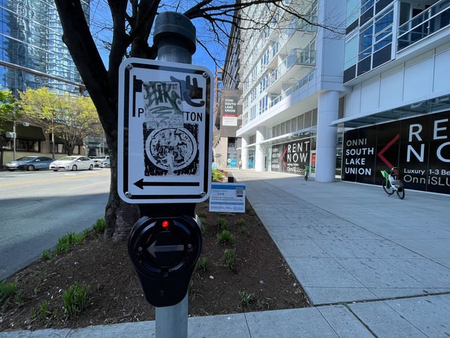 An audio-enabled crosswalk button in Seattle's South Lake Union neighborhood that's been altered to sound like Amazon founder Jeff Bezos is speaking. (GeekWire Photo / Taylor Soper)