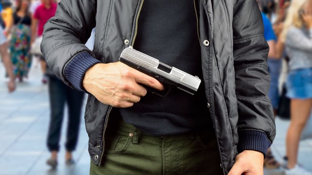 closeup of an armed terrorist with street background