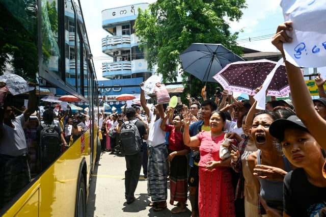 Relatives gather around a bus carrying prisoners being released from prison to commemorate the Buddhist New Year in Yangon
