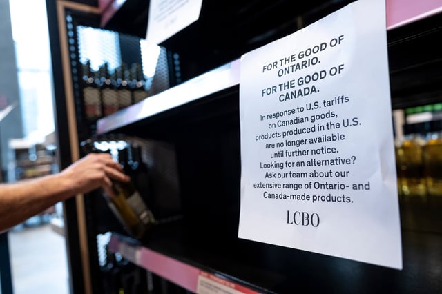 A worker removes bottles of American-made wine from a shelf at the Liquor Control Board of Ontario (LCBO) Queen's Quay store in Toronto, Ontario, Canada, on March 4, 2025.