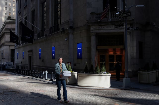 A woman walks along Wall Street outside the New York Stock Exchange (NYSE) in New York City, U.S., April 9, 2025. REUTERS/Kylie Cooper/File Photo