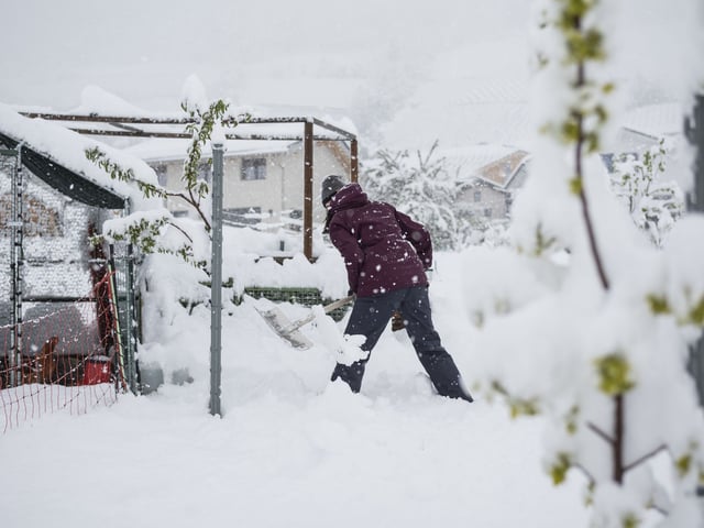Eine Bewohnerin schaufelt den Schnee rund um den Hühnerstall im Weiler Valencon.