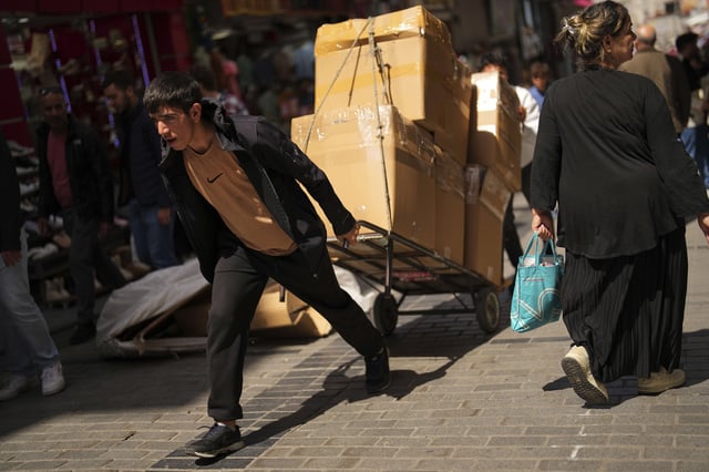 A man pulls a trolley with goods at Eminonu commercial district in Istanbul, Turkey, Thursday, April 17, 2025. (AP Photo/Francisco Seco)